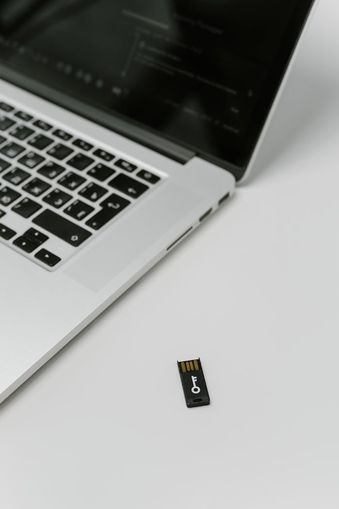 Close-up of a USB security key beside a laptop, emphasizing data encryption.